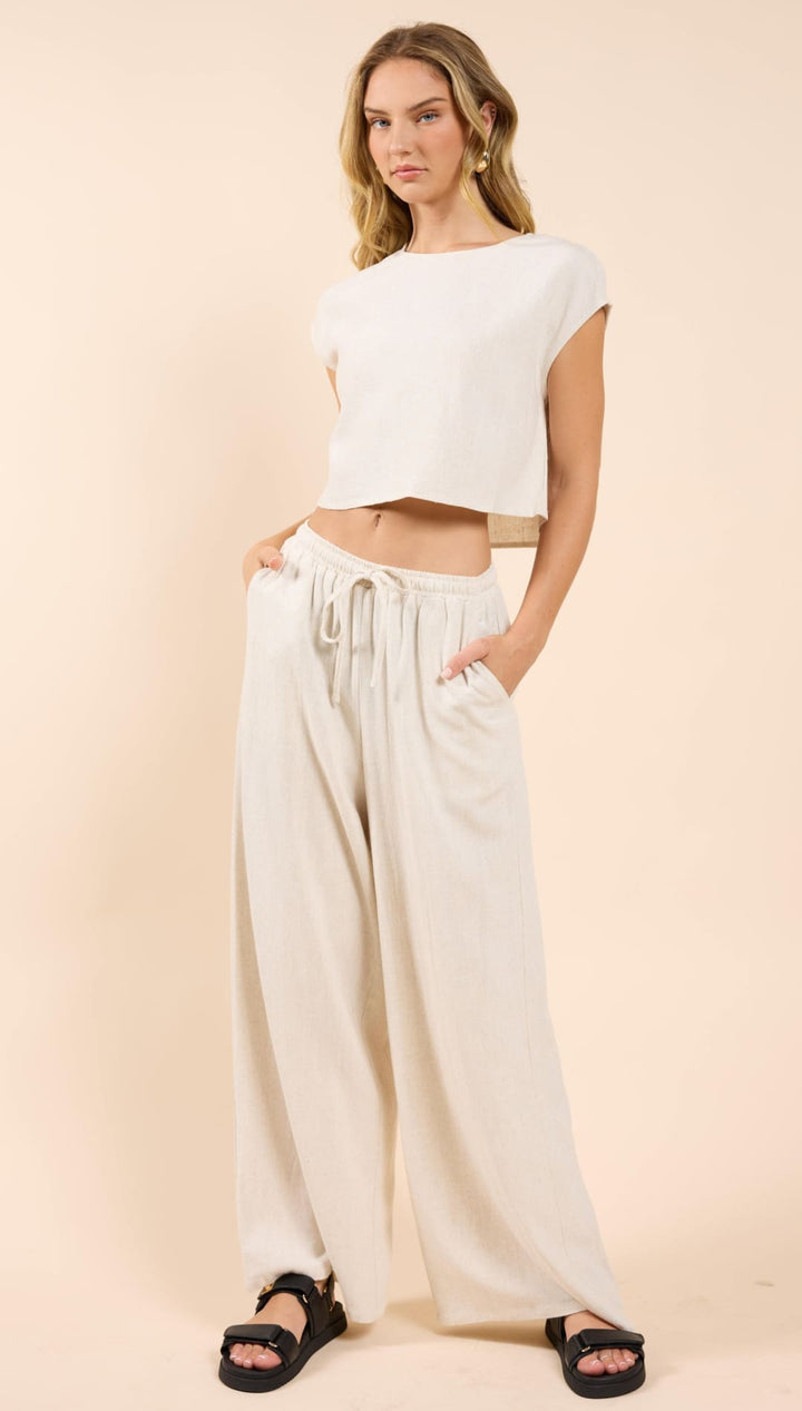 Woman in a matching crop top and wide-leg pants.