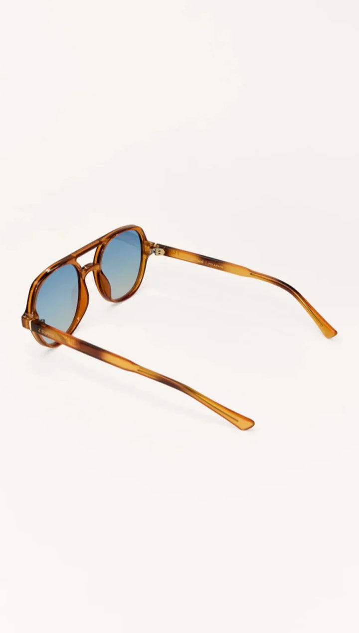 Tortoiseshell sunglasses with blue lenses and gold hardware.