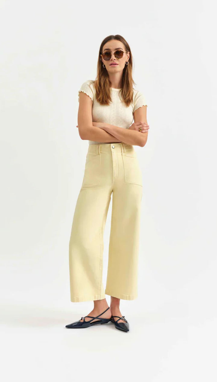 Woman in yellow pants and a cream top.