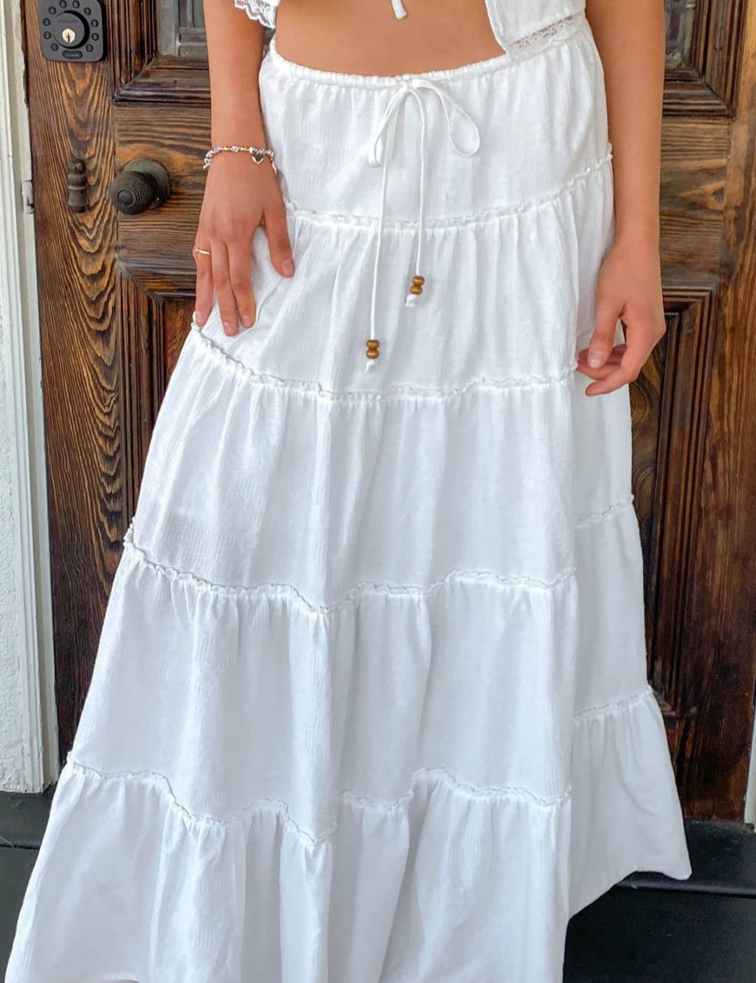 White tiered maxi skirt with ruffled layers and a drawstring waist.