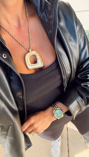 Gold-toned geometric pendant necklace with a twisted rope chain.