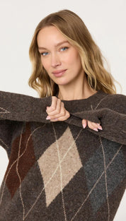 A cozy, chunky knit sweater in a rich brown hue with an argyle pattern featuring beige and dark brown diamonds outlined by thin white lines.