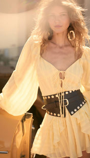 A flowing, pale yellow chiffon dress with a square neckline and long sleeves.