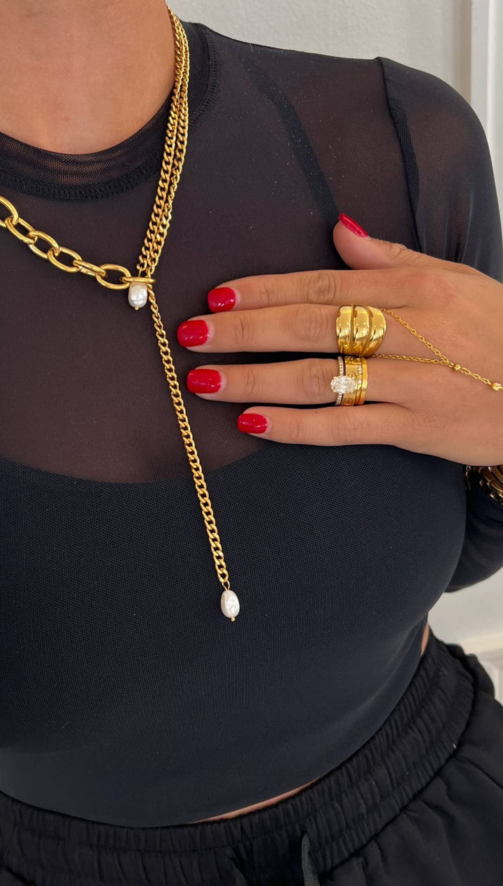 Gold chain necklace with a layered design featuring thick curb links and delicate fine chains, accented by two white pearls at the center.