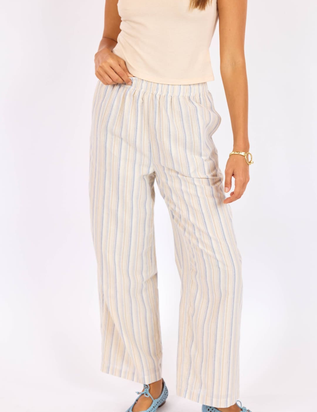 Wide-leg striped trousers in a soft cream and light blue vertical stripe pattern, made from lightweight fabric with an elastic waistband