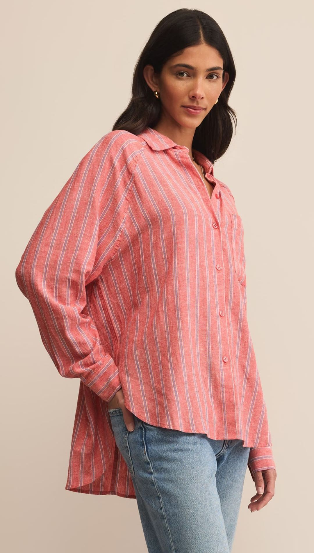 Woman in a pink striped button-down shirt and jeans.