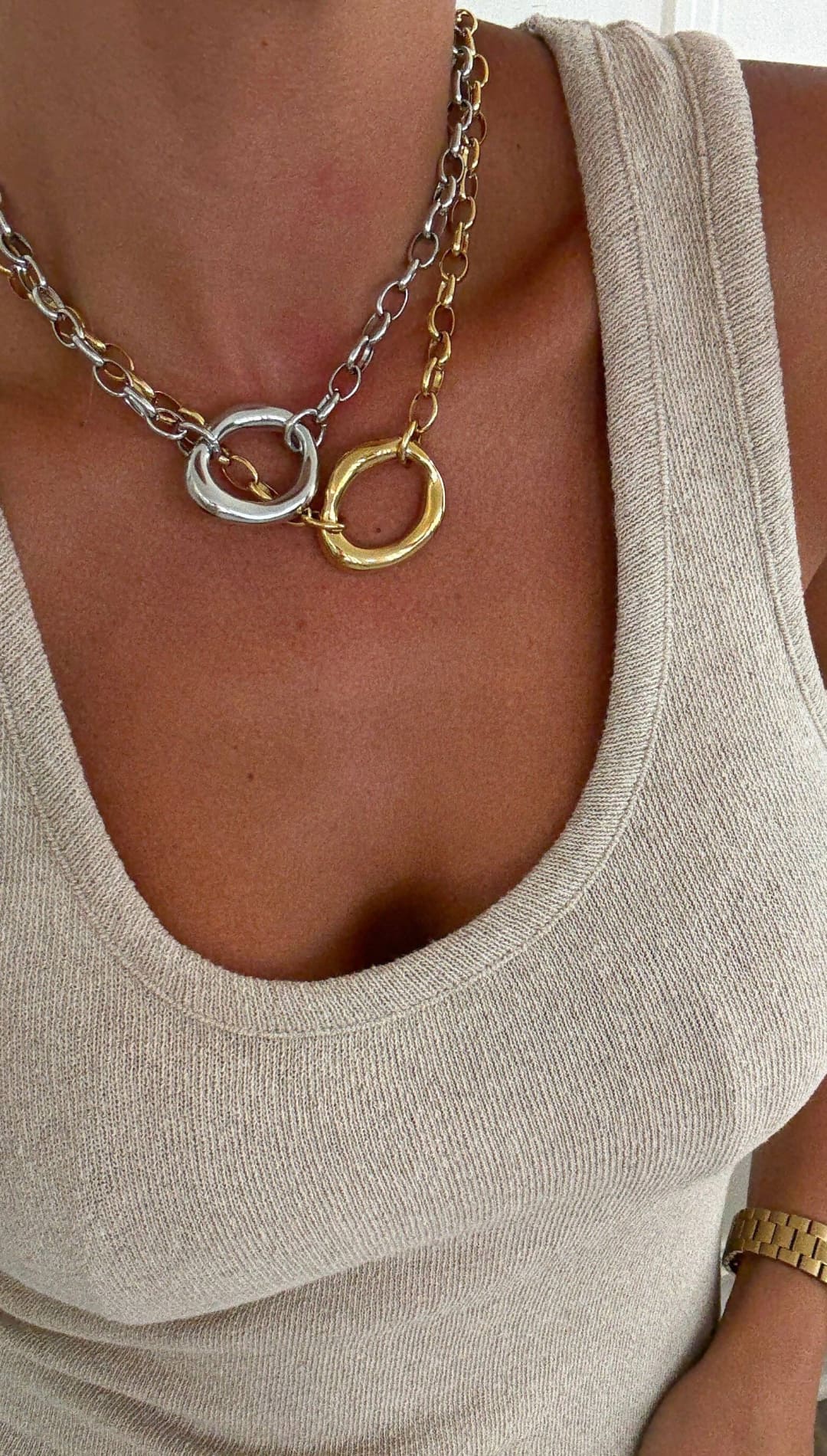 A layered necklace featuring interlocking silver and gold-toned circular links with a chunky chain design.