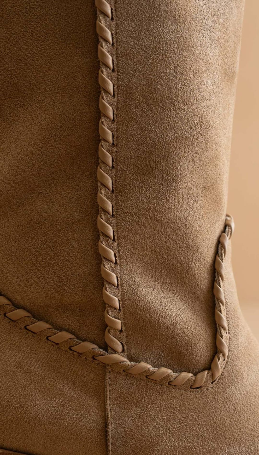 Tan suede boot with distinctive braided stitching along the side.