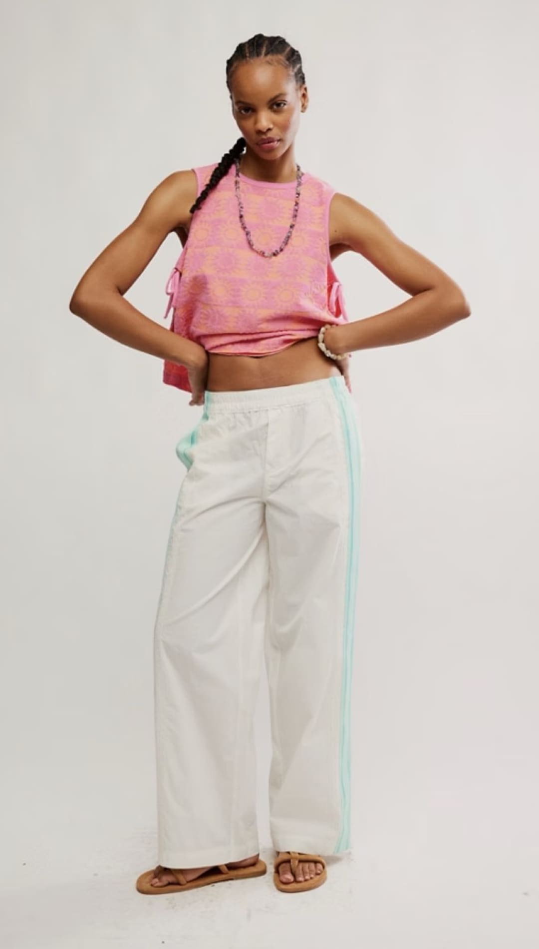 Woman in pink top and white pants.