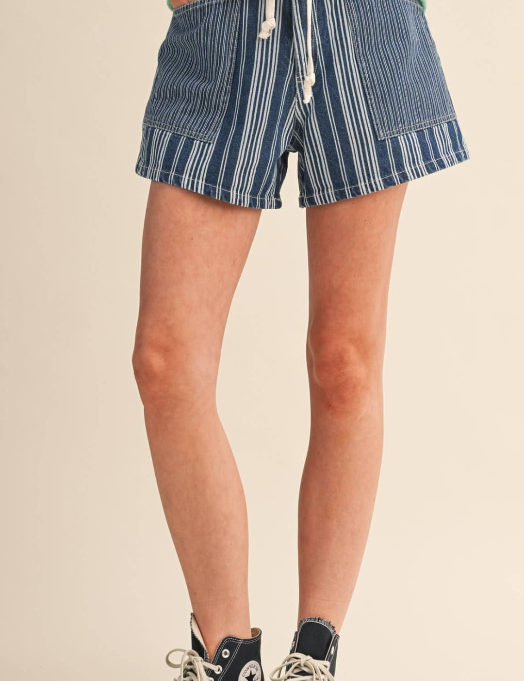 Blue and white vertically striped denim shorts with a drawstring waistband.