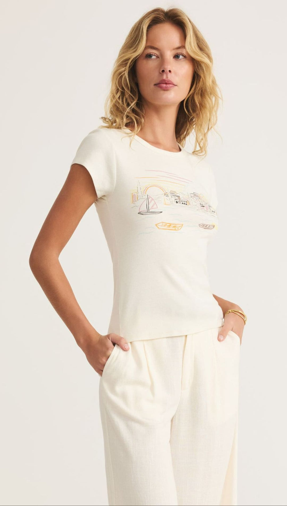 Woman wearing a cream-colored t-shirt and pants.