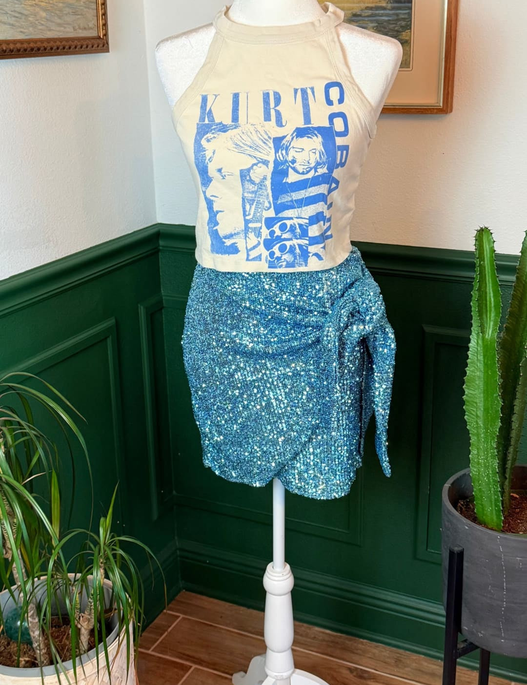 A shimmering blue sequined wrap skirt displayed on a mannequin.