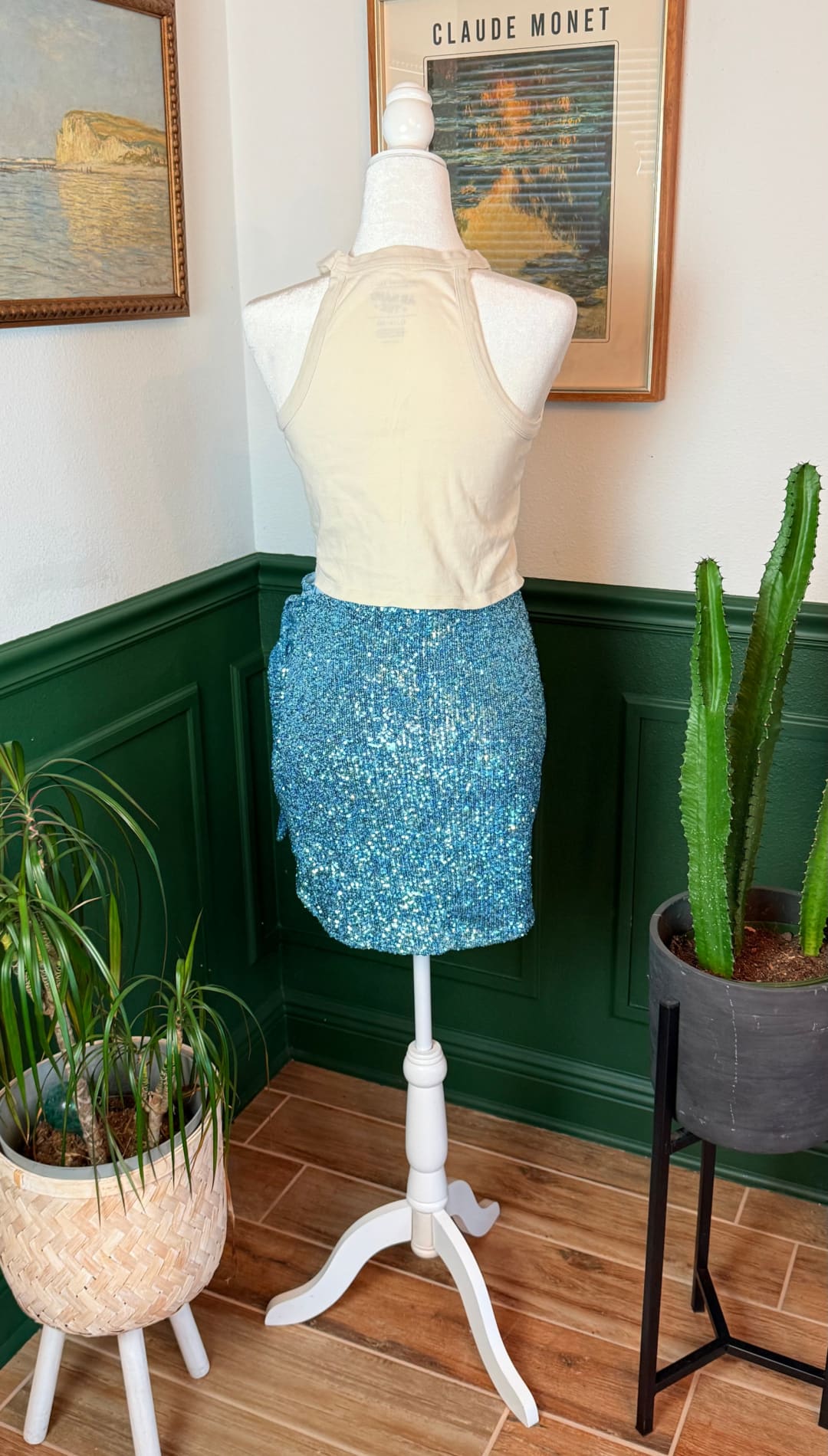 Blue sequined mini skirt worn with a cream halter top on a mannequin.