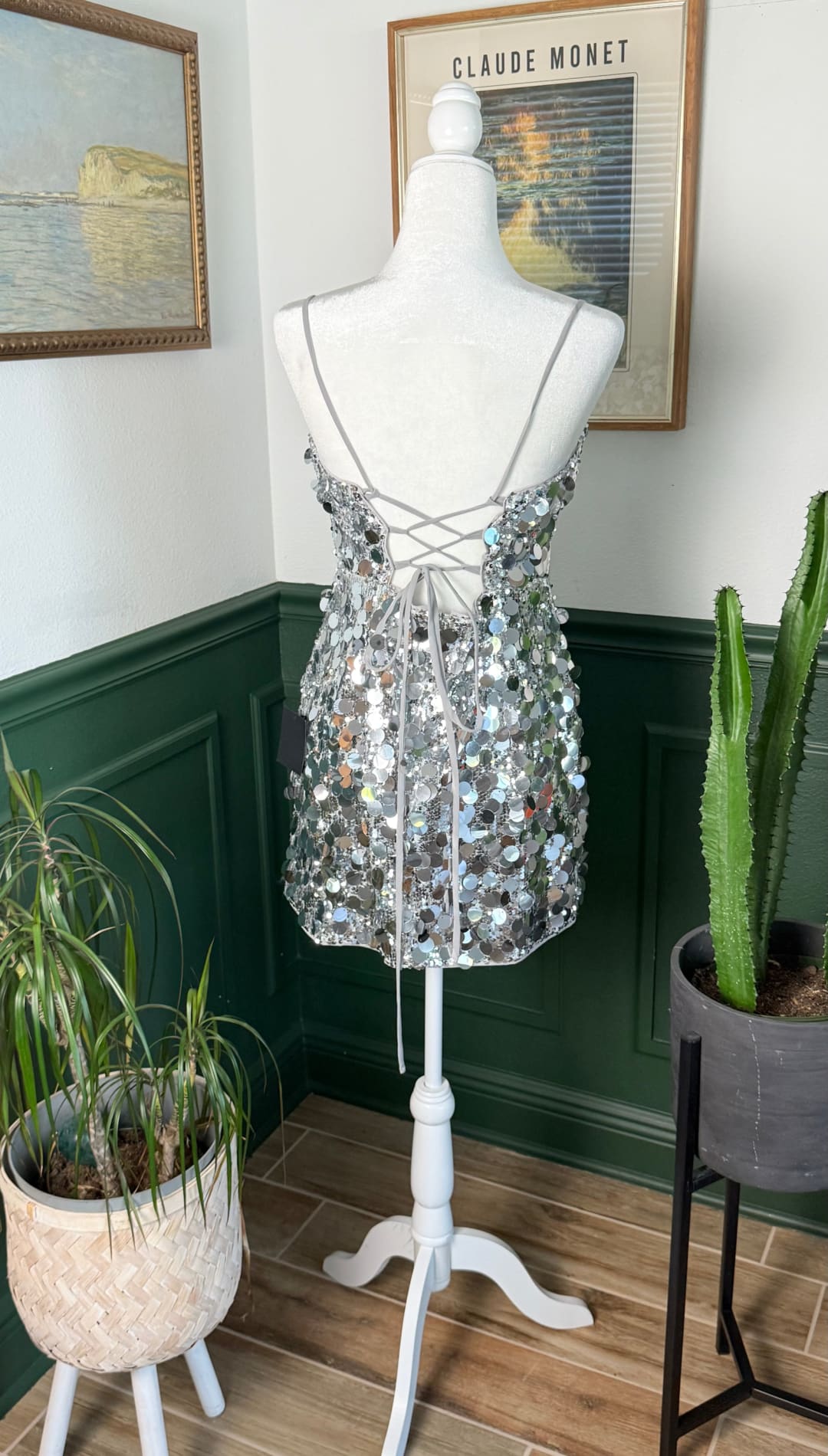 Silver sequined mini dress with thin straps and a lace-up back.