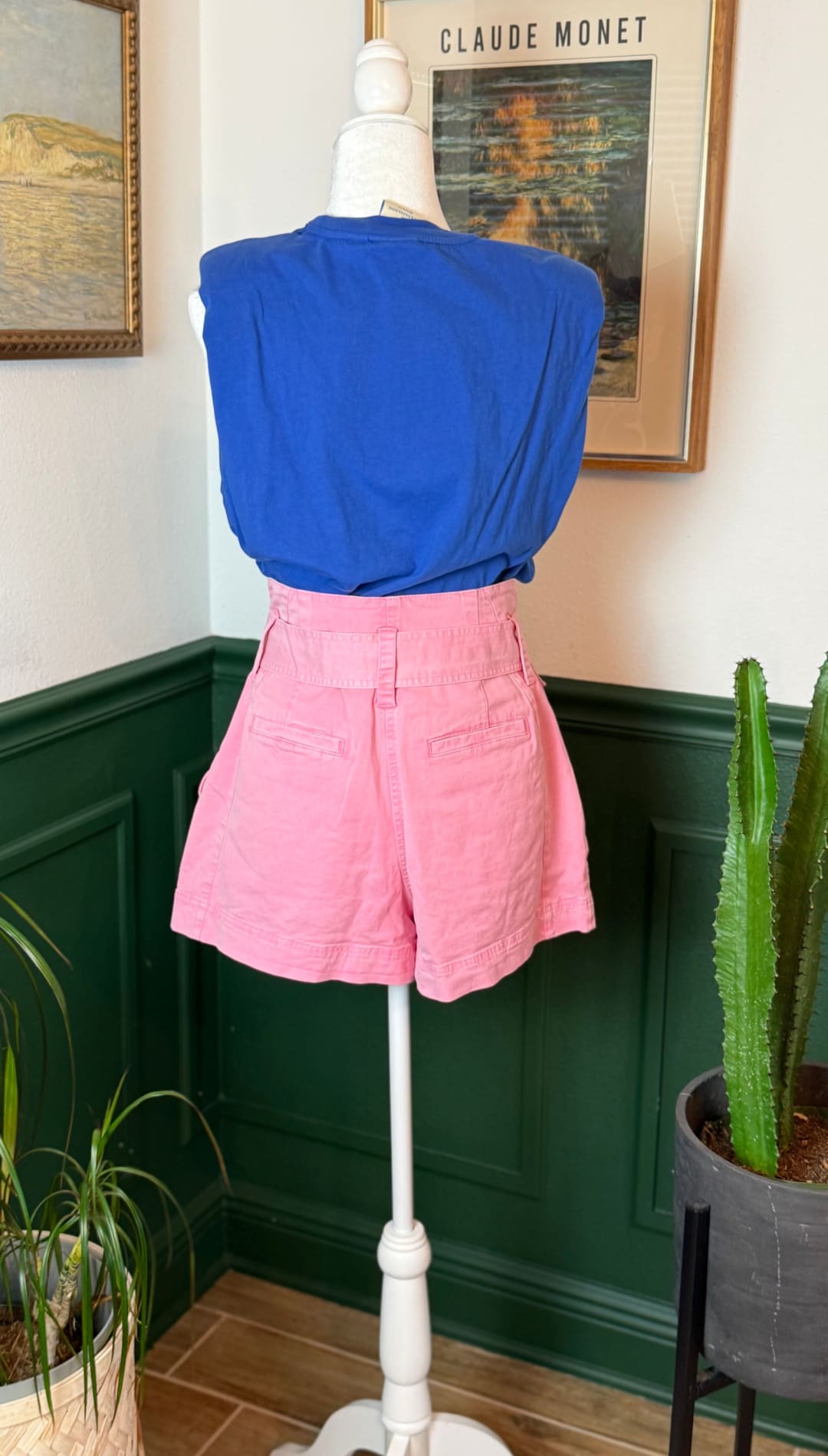 Pink high-waisted shorts with a belt loop and front pockets, displayed on a mannequin.