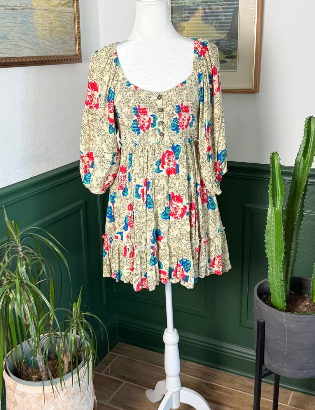 A floral print dress in beige with red and blue blossoms, featuring puffed sleeves and a button-front design.