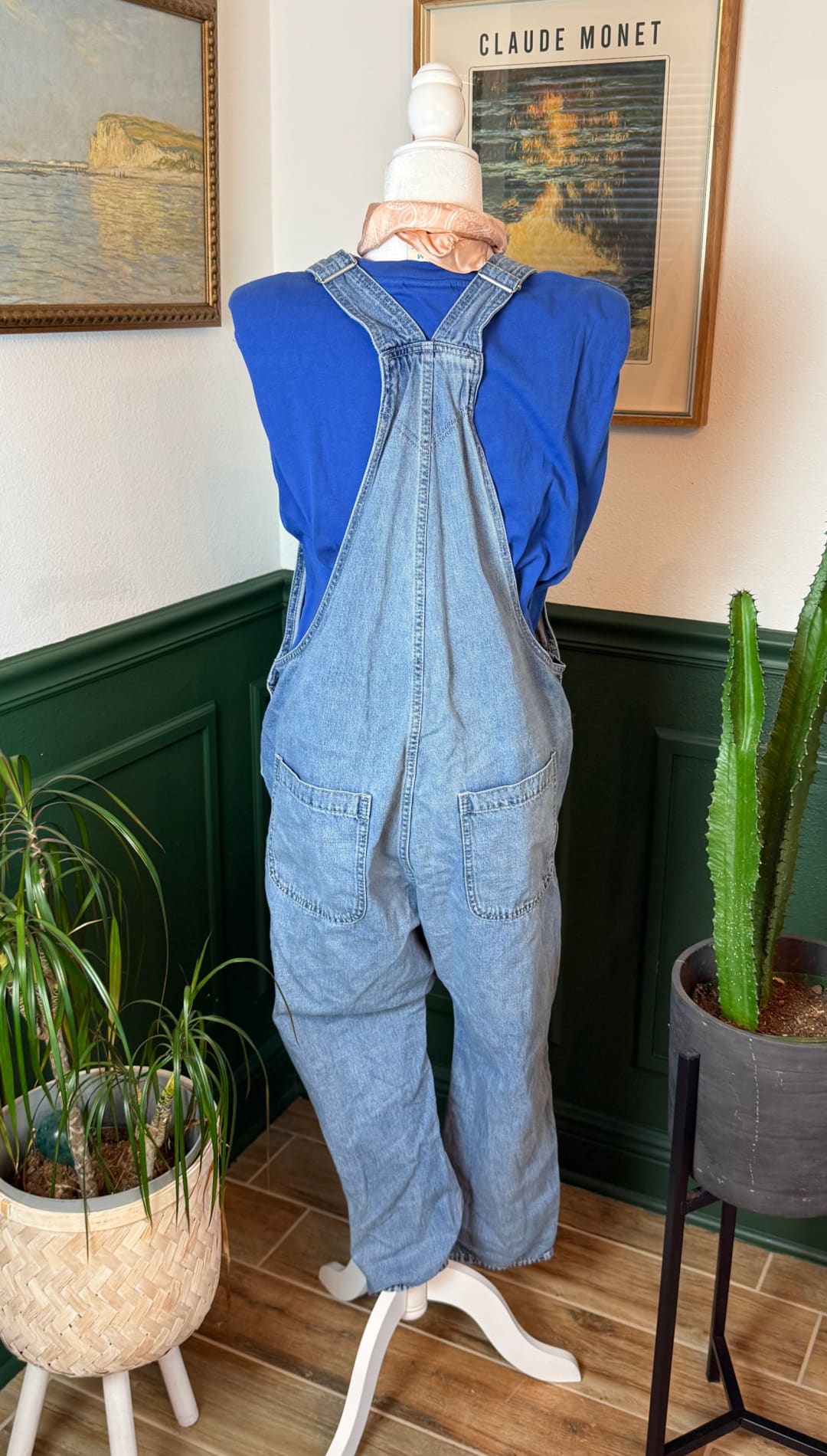 Light-wash denim overalls with adjustable straps and front pockets, displayed on a mannequin.