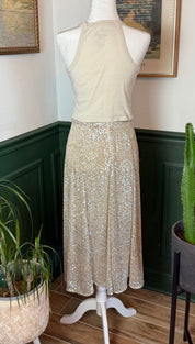 A shimmering gold sequined midi skirt displayed on a mannequin.