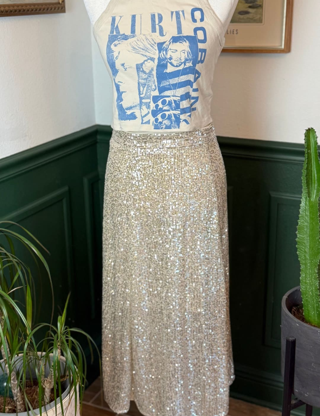 A shimmering gold sequin midi skirt displayed on a mannequin.