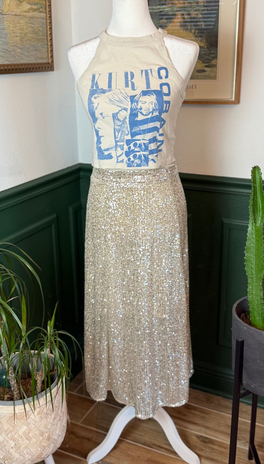 A shimmering gold sequin midi skirt displayed on a mannequin.
