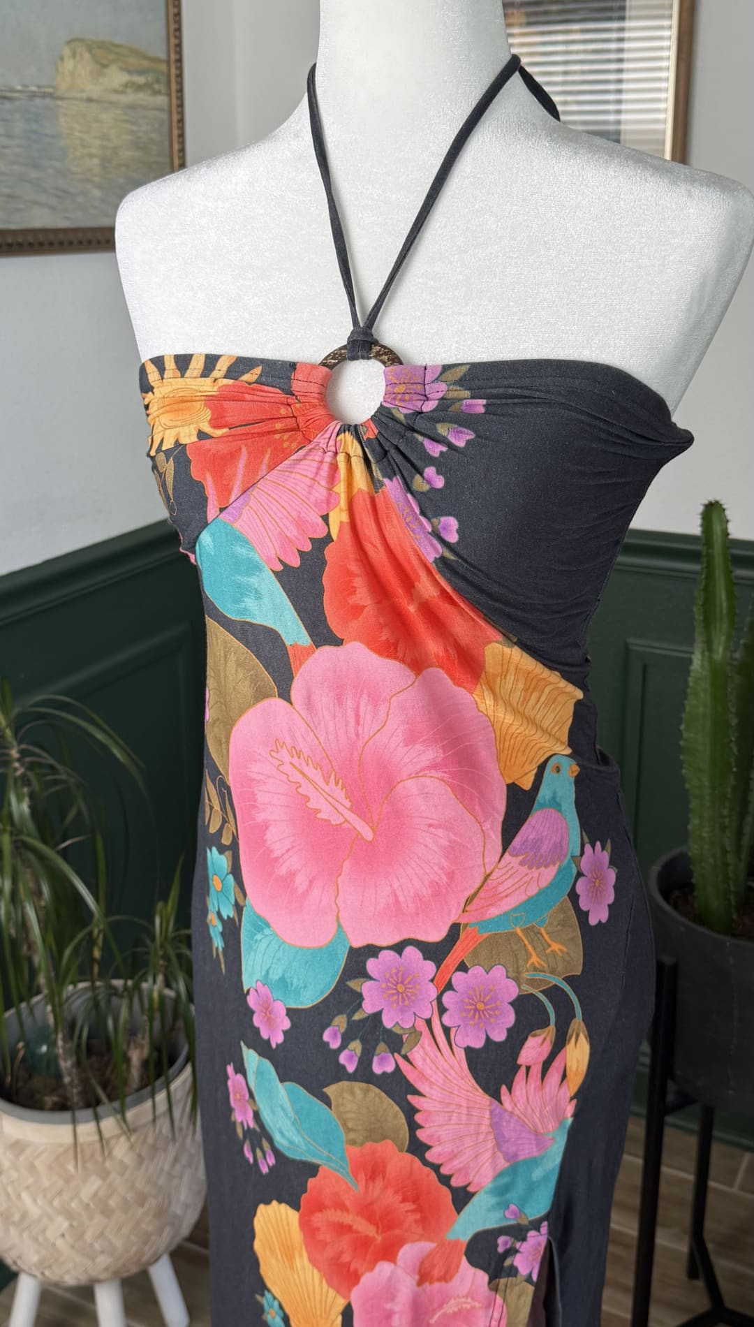 A vibrant floral halter dress with bold pink, orange, and teal blossoms on a dark navy background.