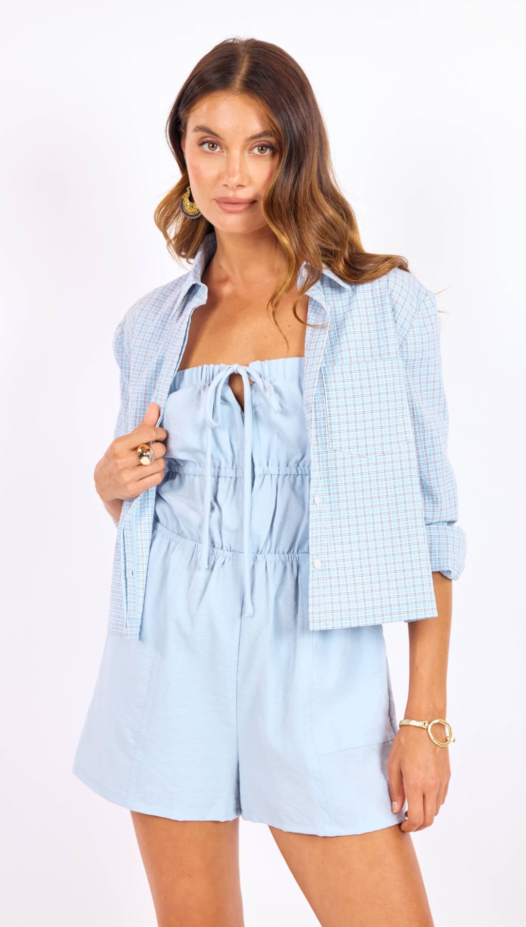 Light blue, textured fabric romper with a drawstring neckline and elastic waist.