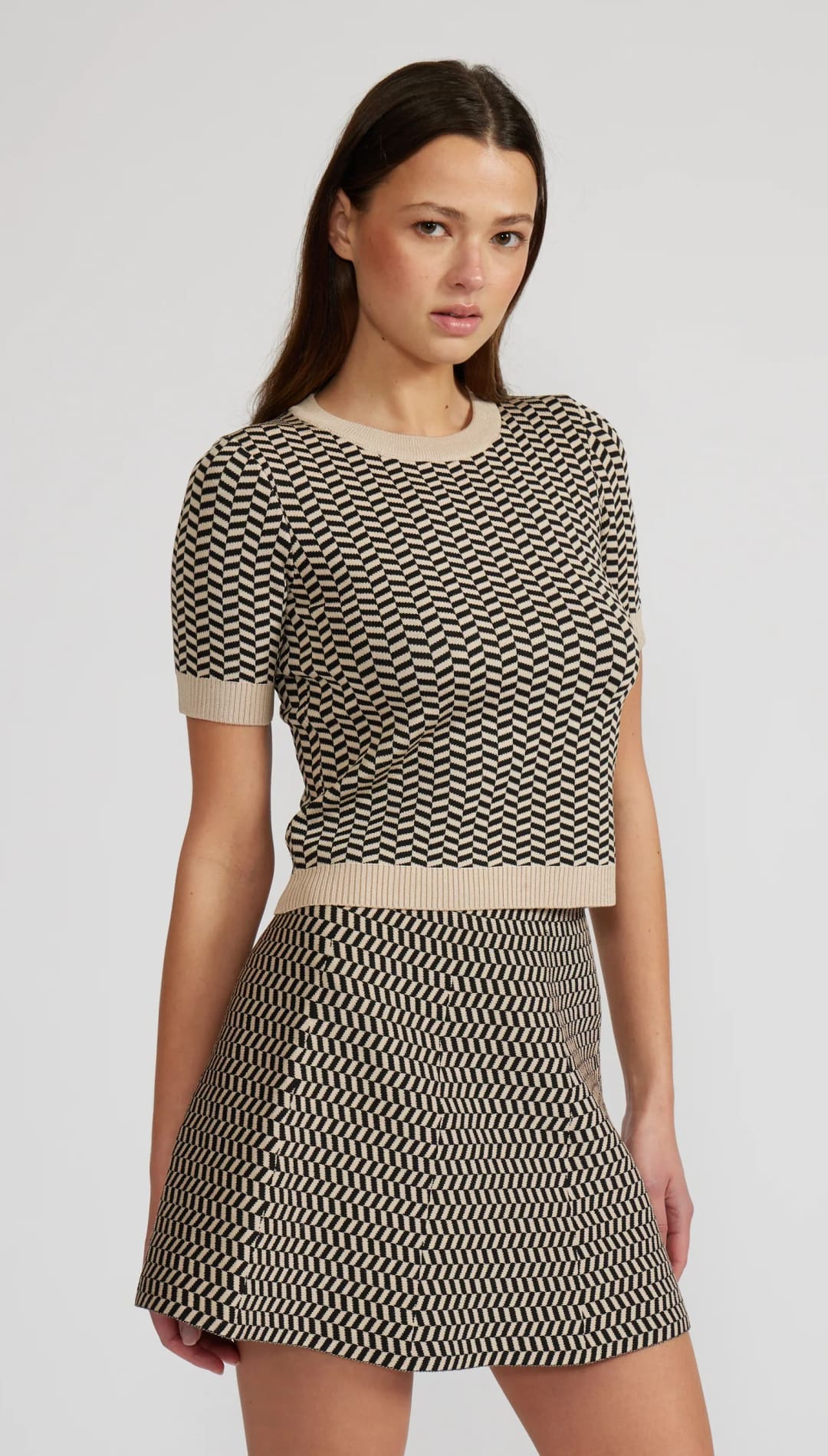 Women’s two-piece knitted set with a chevron pattern, consisting of a short-sleeve top and a mini skirt.