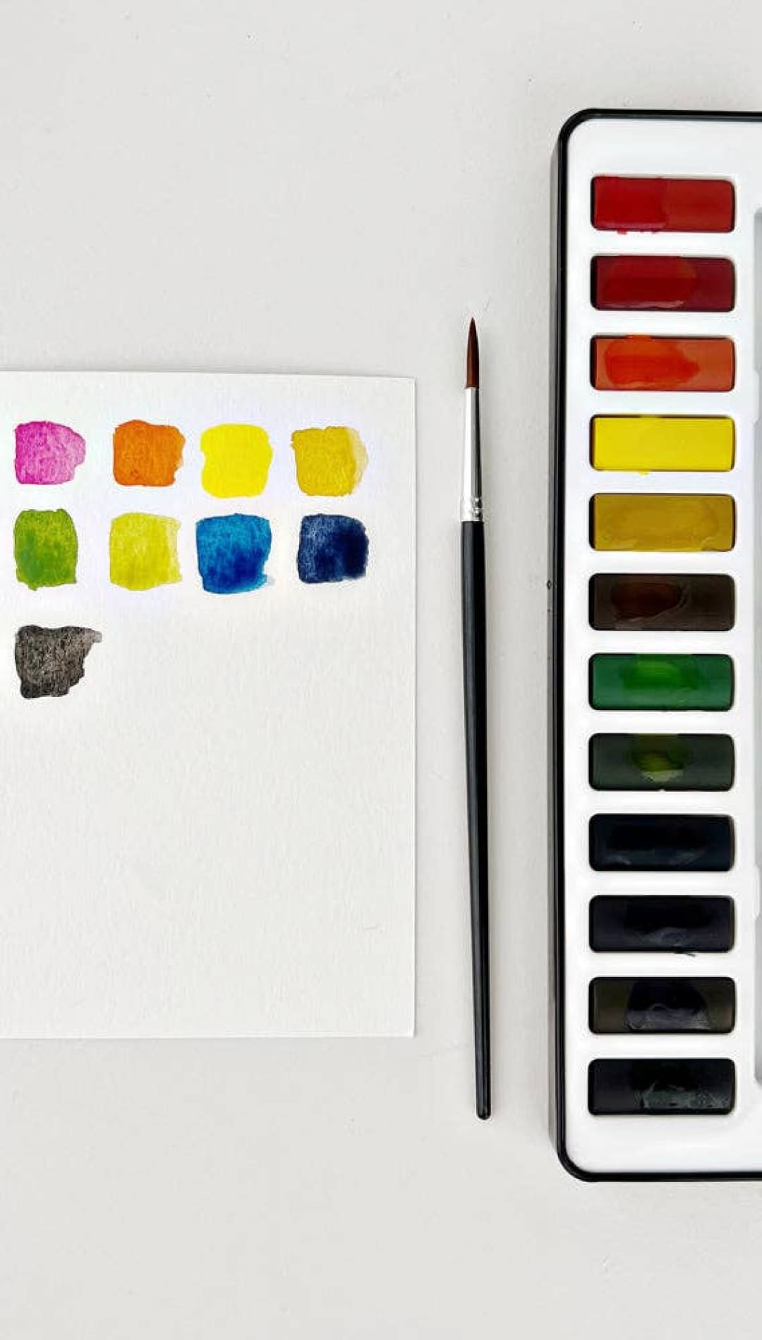 Watercolor paint set with vibrant colors and a sleek black case.