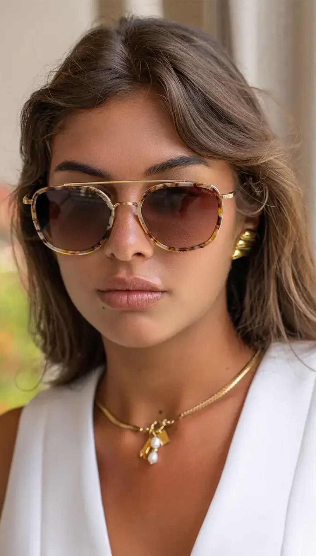 Tortoiseshell-patterned aviator sunglasses with gold metal frames and gradient brown lenses.