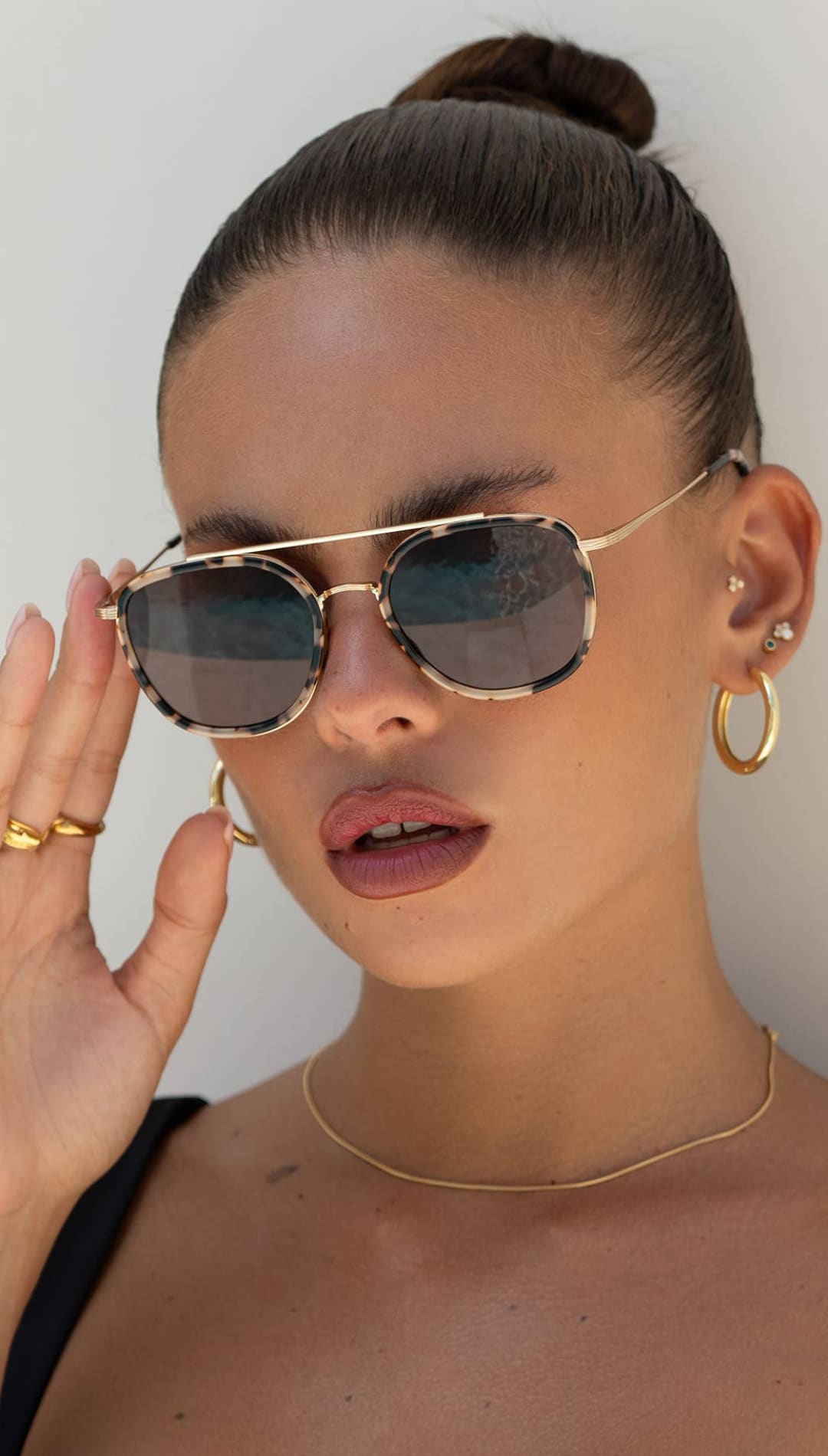 Gold-framed aviator sunglasses with tortoiseshell-patterned lenses.