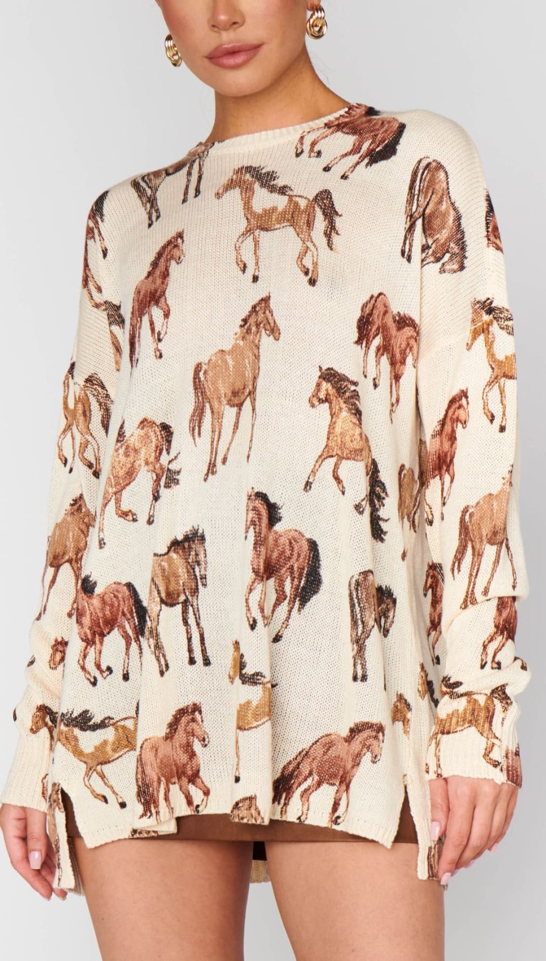 Cream-colored, long-sleeved sweater with a brown horse print.