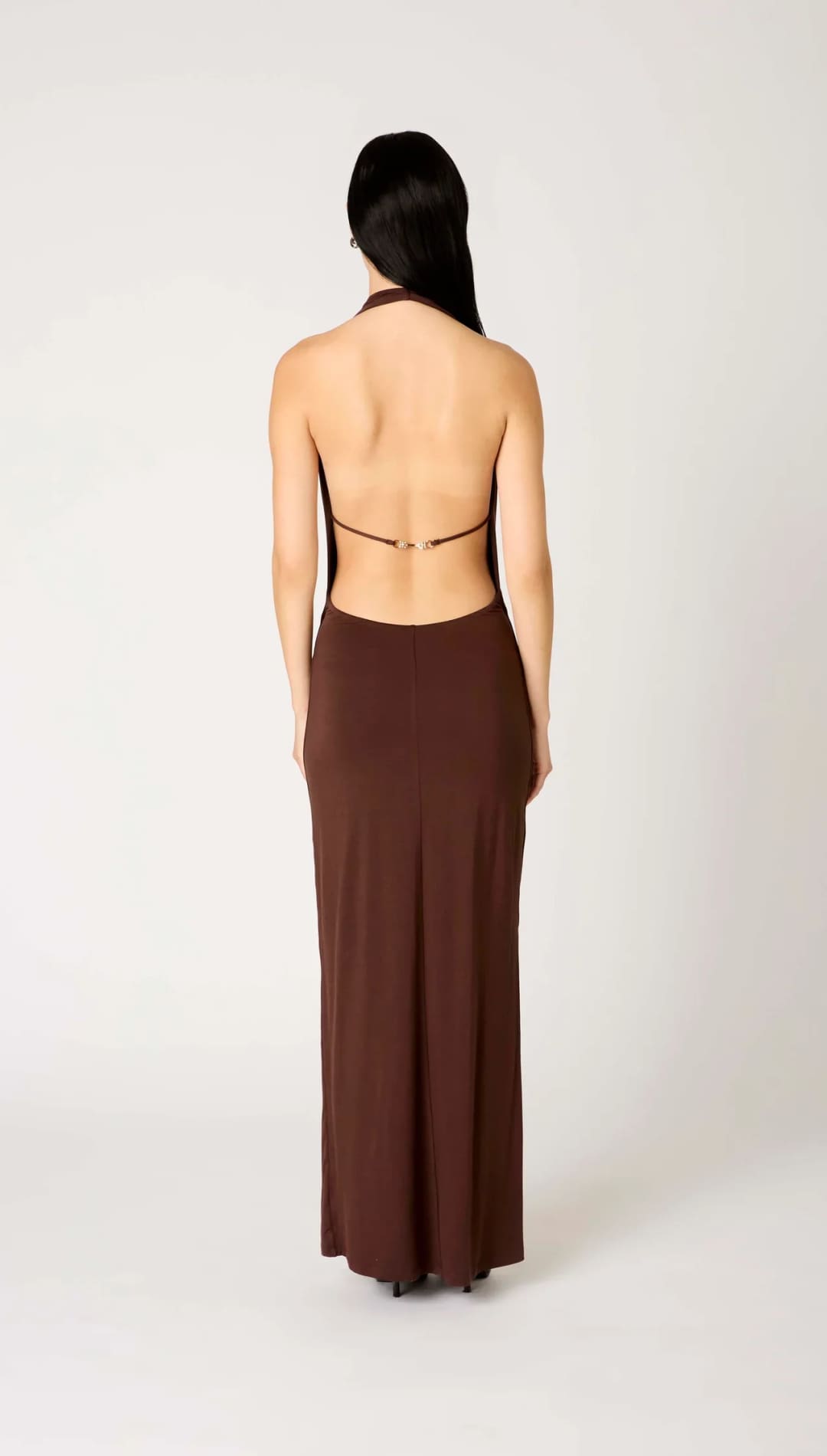 Brown halter neck maxi dress with open back design and thin straps.