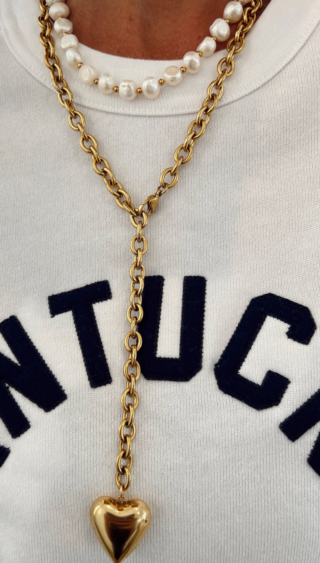 Gold-toned chain necklace with a polished heart-shaped pendant.