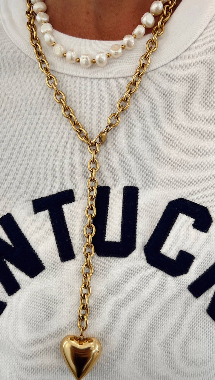 Gold-toned chain necklace with a polished heart-shaped pendant.