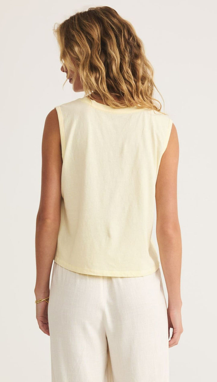 Woman wearing a yellow sleeveless top.