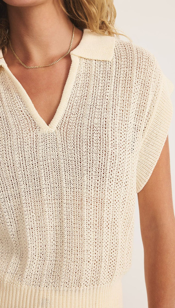 Cream-colored knit polo shirt.