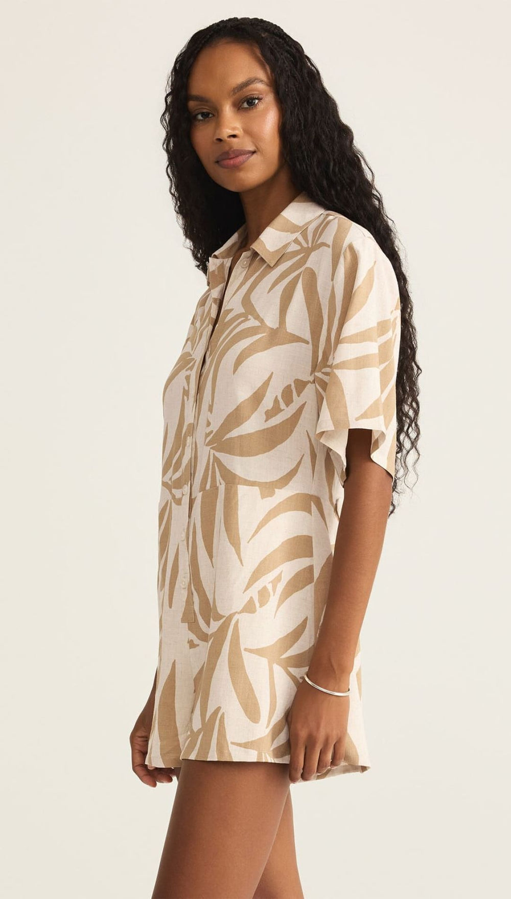 Woman’s beige and white leaf-patterned shirt dress.