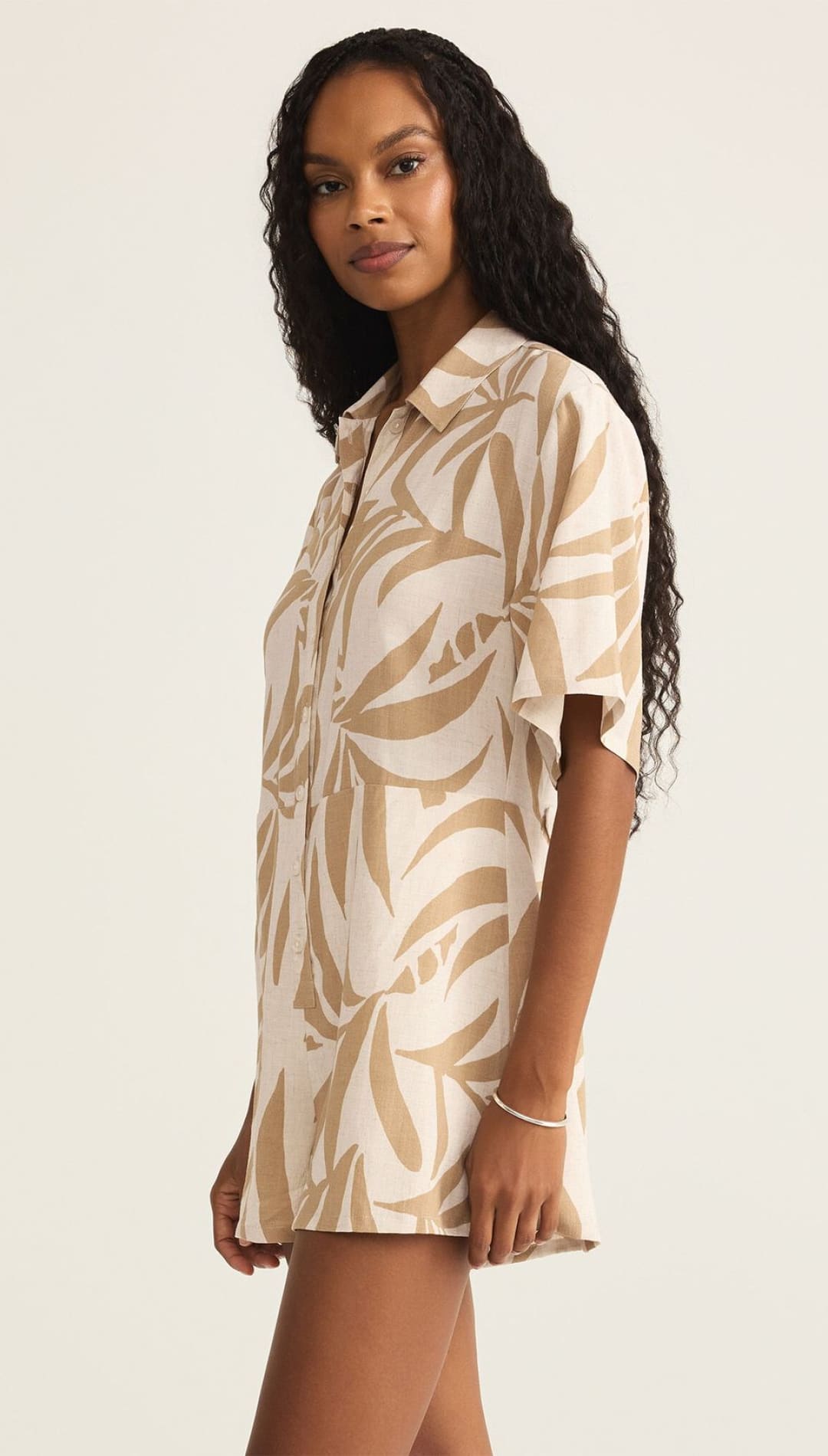Woman’s beige and white leaf-patterned shirt dress.