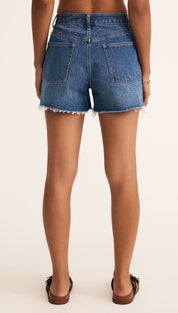 Blue denim shorts with frayed hem.