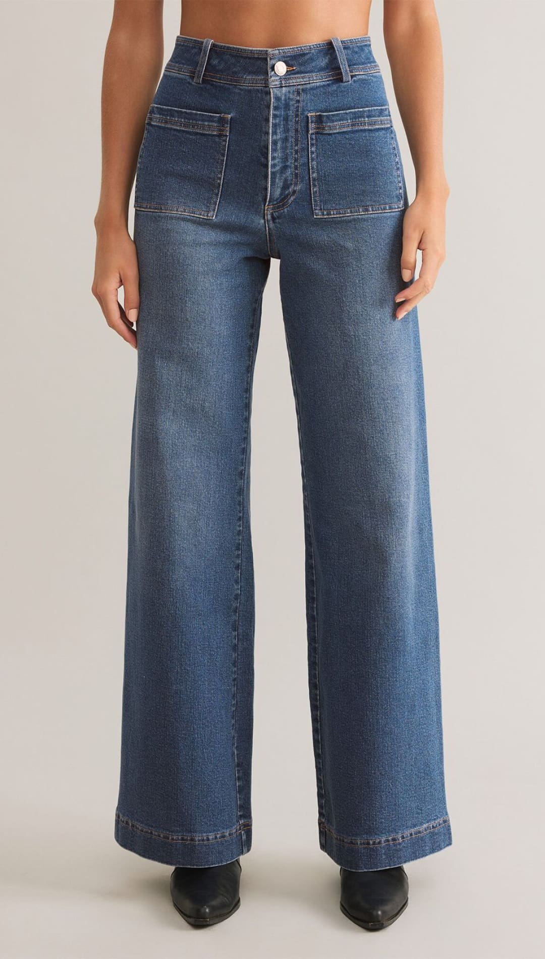 High-waisted, wide-leg blue jeans with large front patch pockets and a visible button fly.