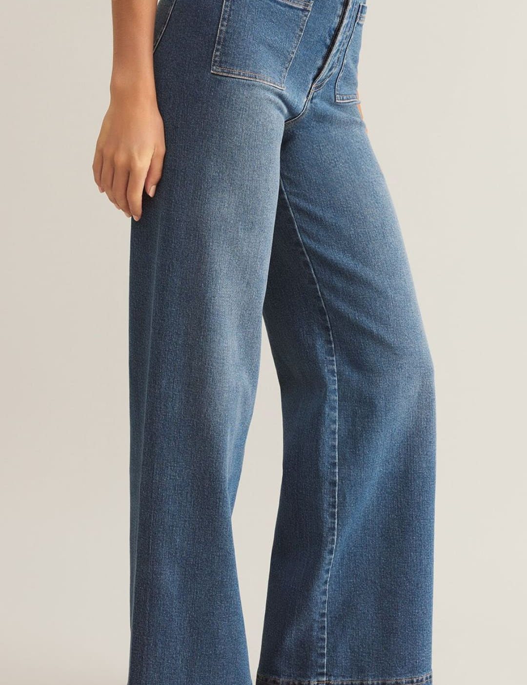 High-waisted, wide-leg blue jeans with front patch pockets and a button fly.