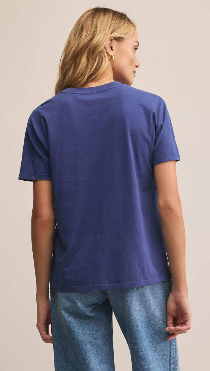 A woman’s short-sleeved blue t-shirt with a crew neck, paired with light wash blue jeans.