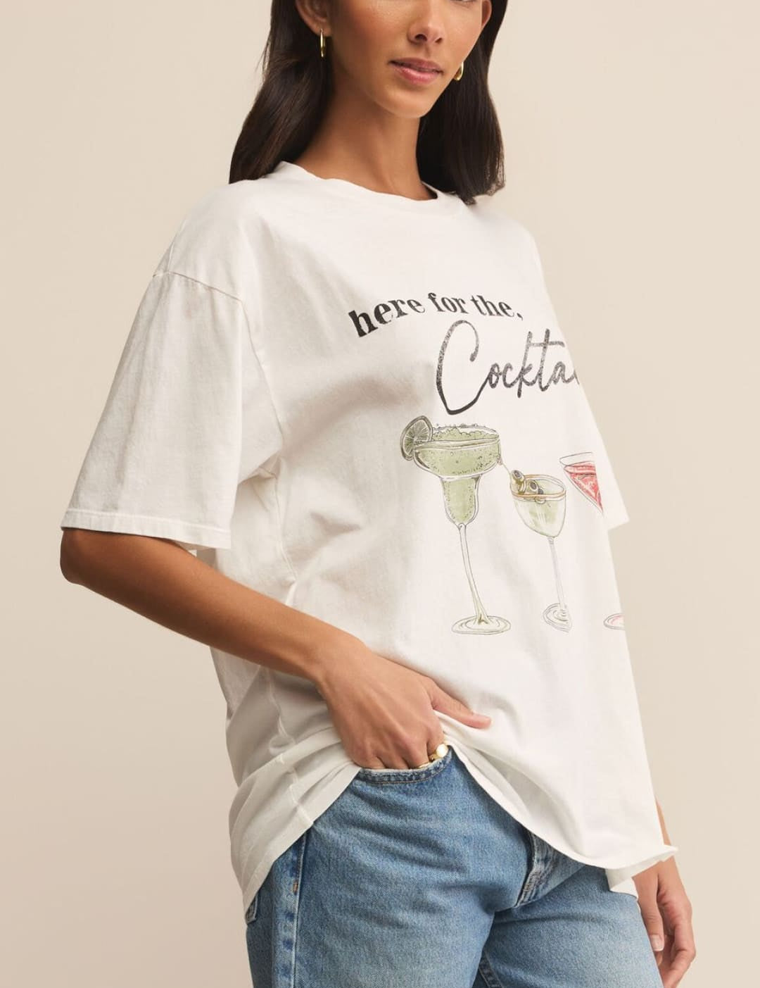 Woman wearing a white graphic t-shirt and blue jeans.