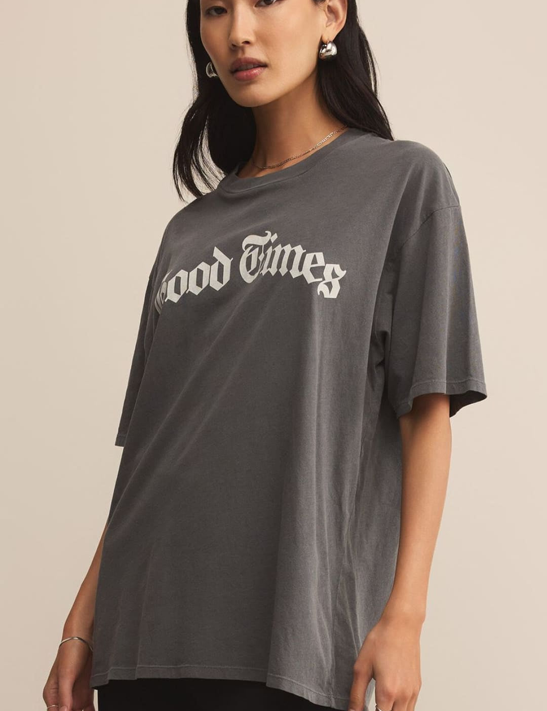 A women’s dark gray oversized t-shirt with ’Good Times’ printed in white on the front.
