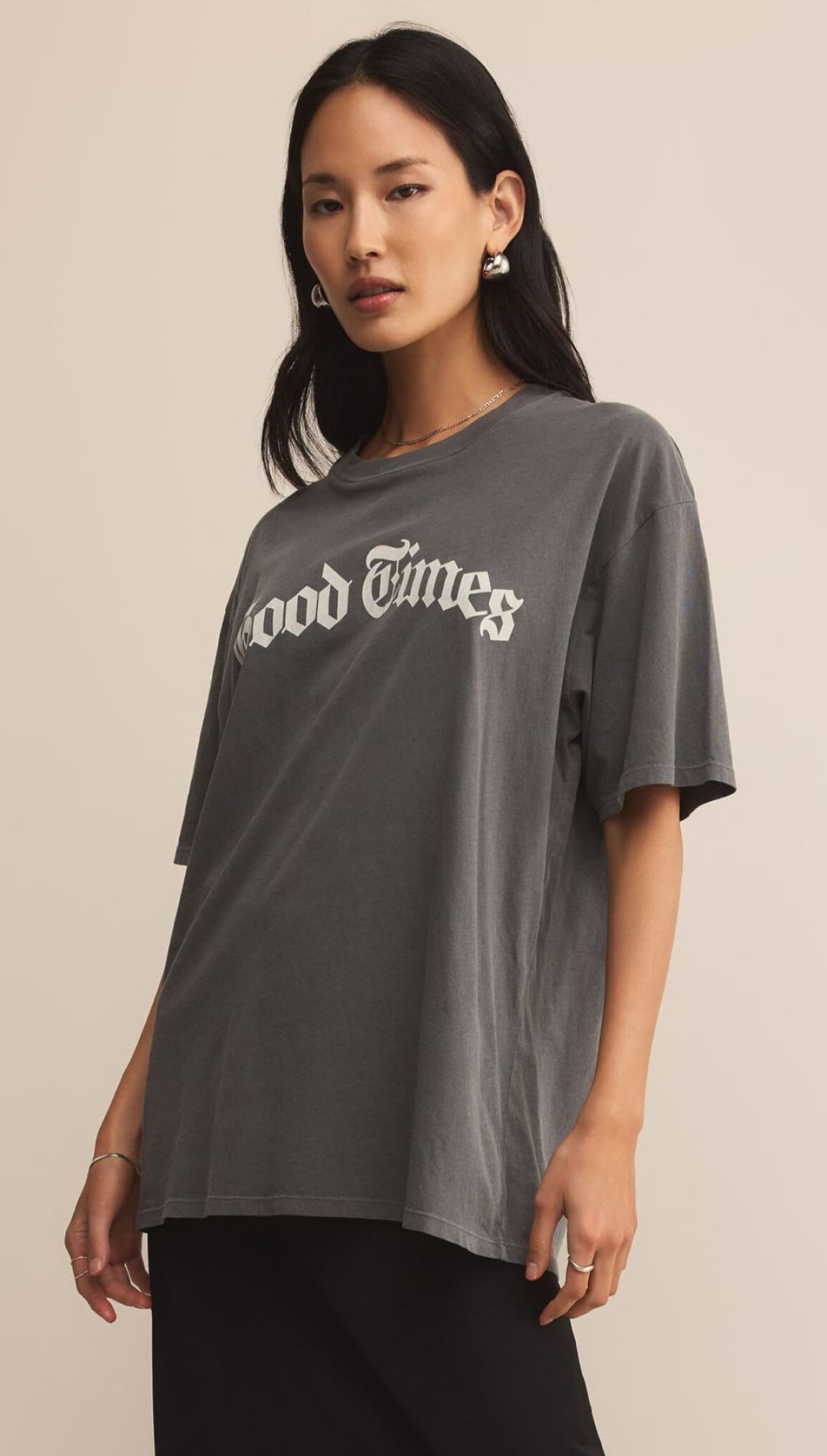 A women’s dark gray oversized t-shirt with ’Good Times’ printed in white on the front.
