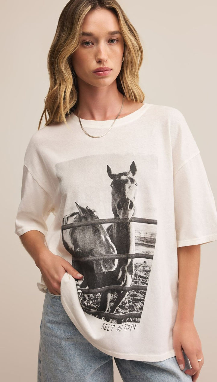A cream-colored short-sleeve t-shirt with a black and white graphic of two horses.