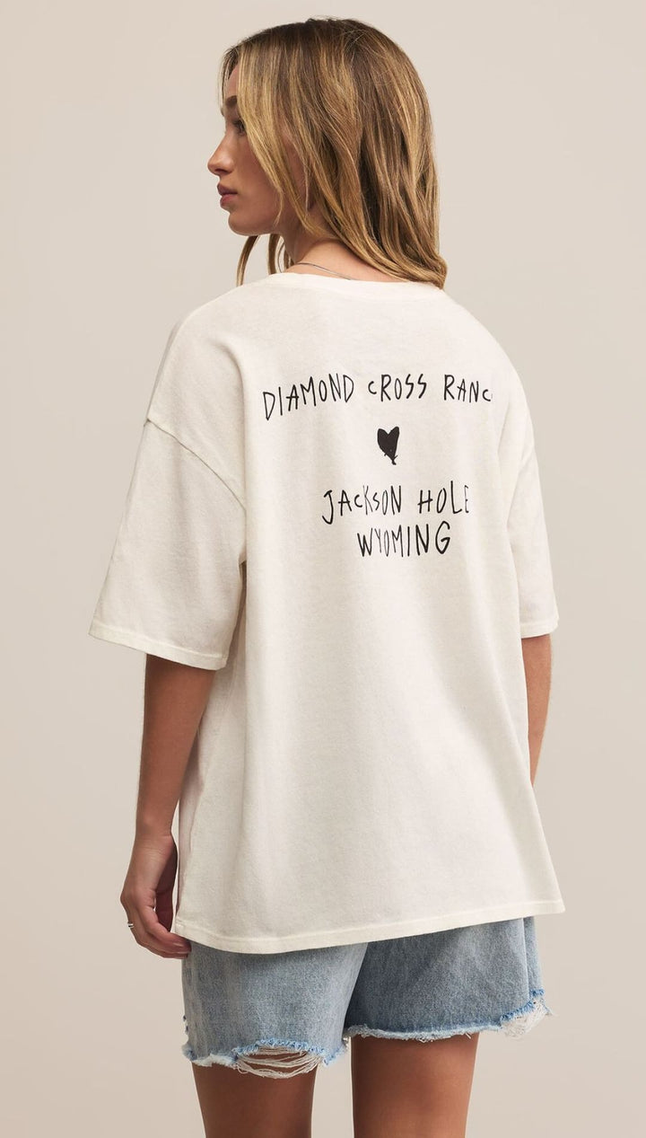 White graphic t-shirt with distressed denim shorts.
