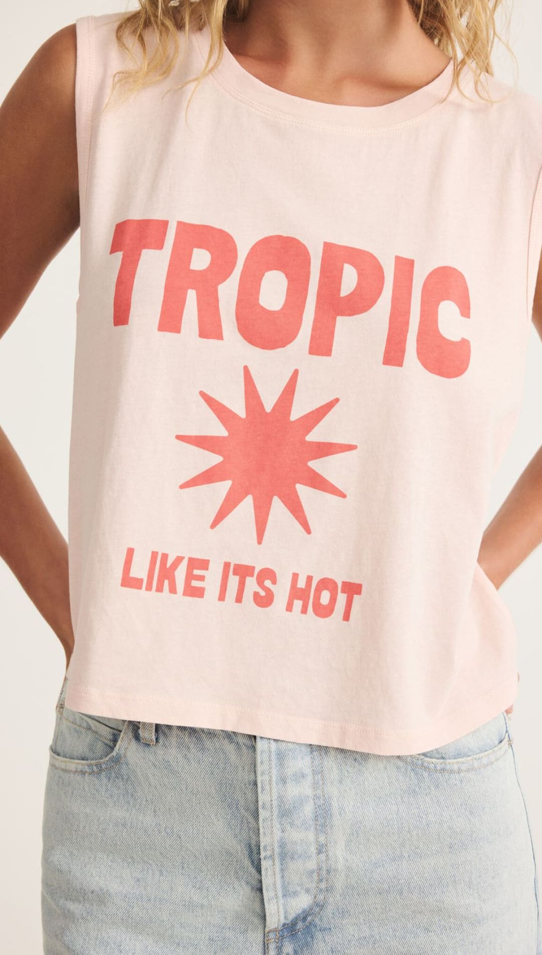 Pink sleeveless shirt with ’Tropic’ and sun graphic.