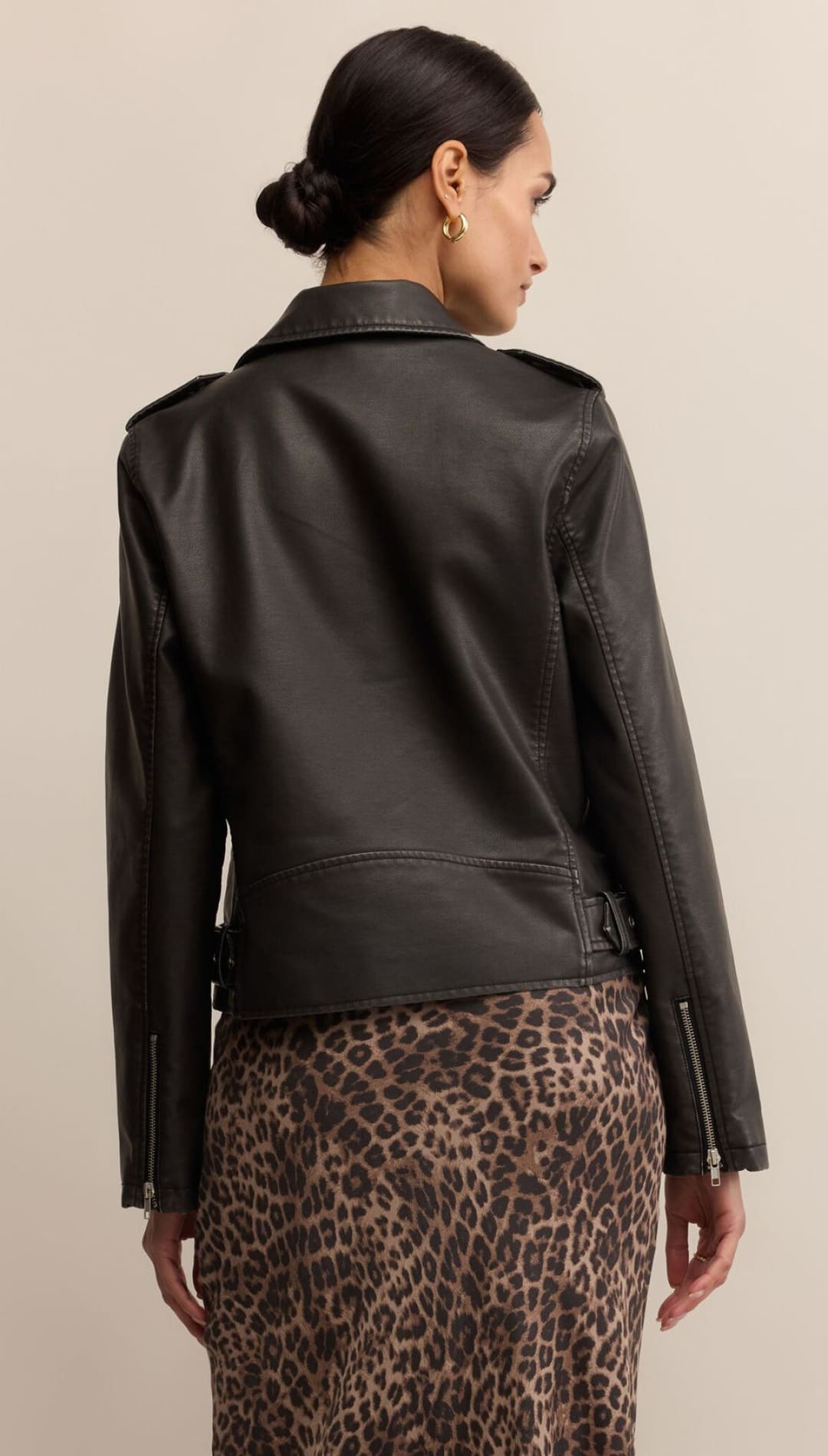 Black leather moto jacket with quilted shoulders and snap closures.