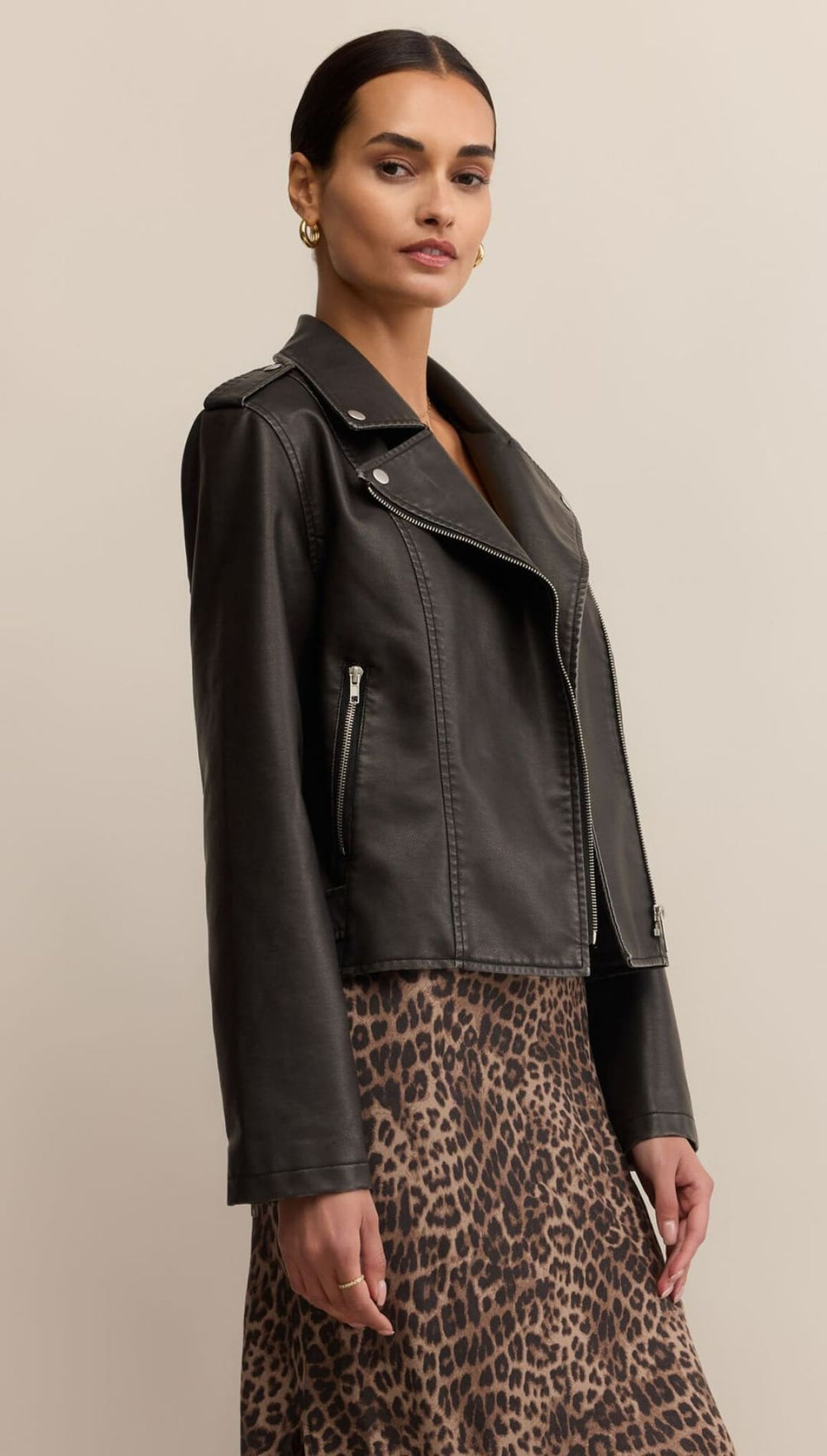 Black leather moto jacket with asymmetrical zipper and patch details.